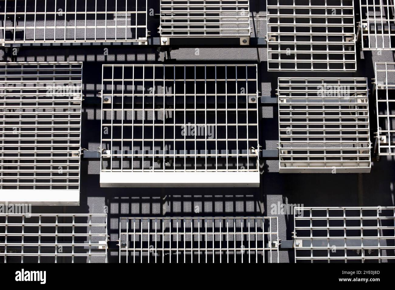 Le pareti di un edificio moderno con prese d'aria in metallo disposte a caso di vari disegni e dimensioni Foto Stock