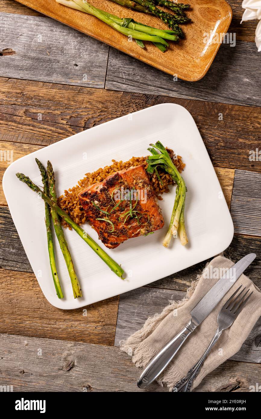 Farina di filetto di salmone glassato d'acero su un letto di riso speziato con asparagi grigliati. Foto Stock