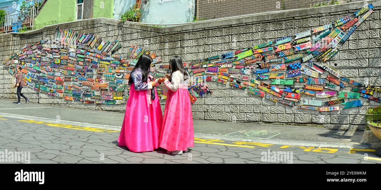 Donne coreane che indossano l'hanbok tradizionale nel villaggio culturale di Gamcheon. È una città all'interno di Gamcheon-dong, distretto di Saha, Busan, Corea del Sud. Foto Stock