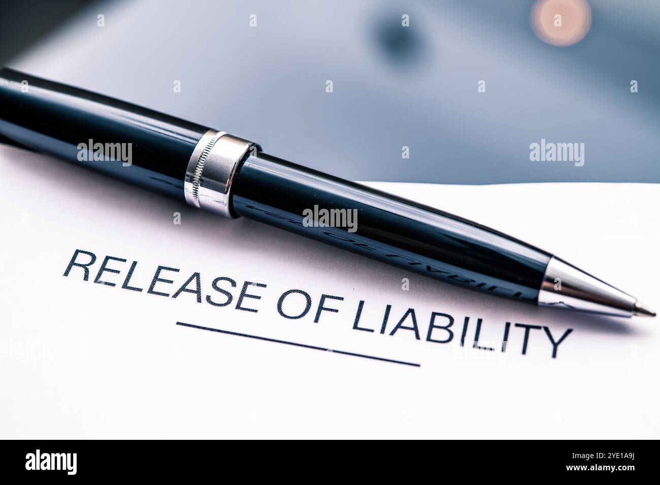 Attenzione dettagliata a un modulo di esonero di responsabilità abbinato a un'elegante penna nera, essenziale per accordi legali, contratti e gestione dei rischi in azienda Foto Stock
