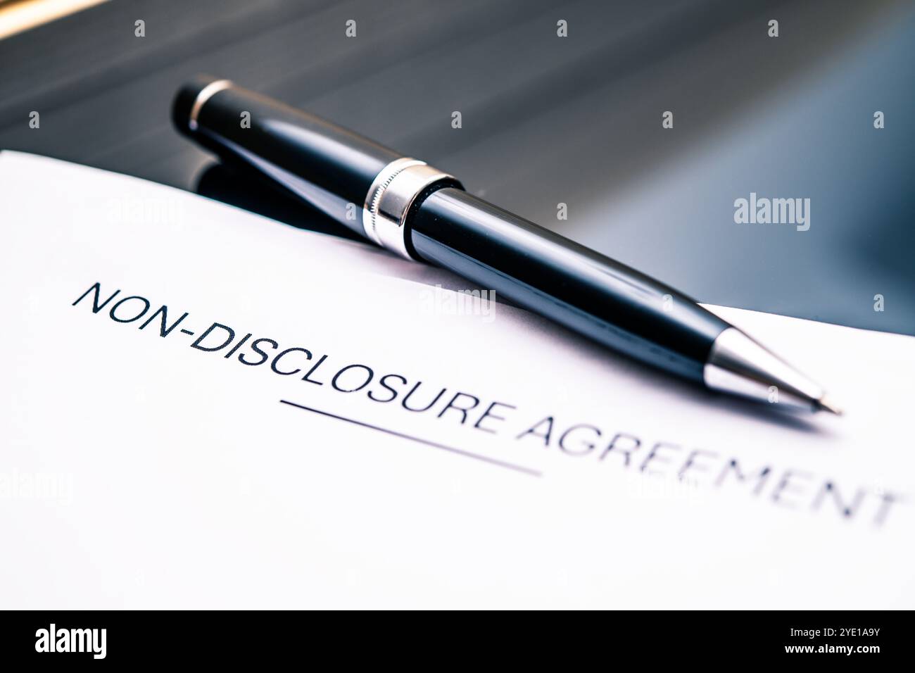 Documento di accordo di non divulgazione con penna elegante che rappresenta la riservatezza, la protezione legale, l'etica aziendale e le transazioni sicure Foto Stock
