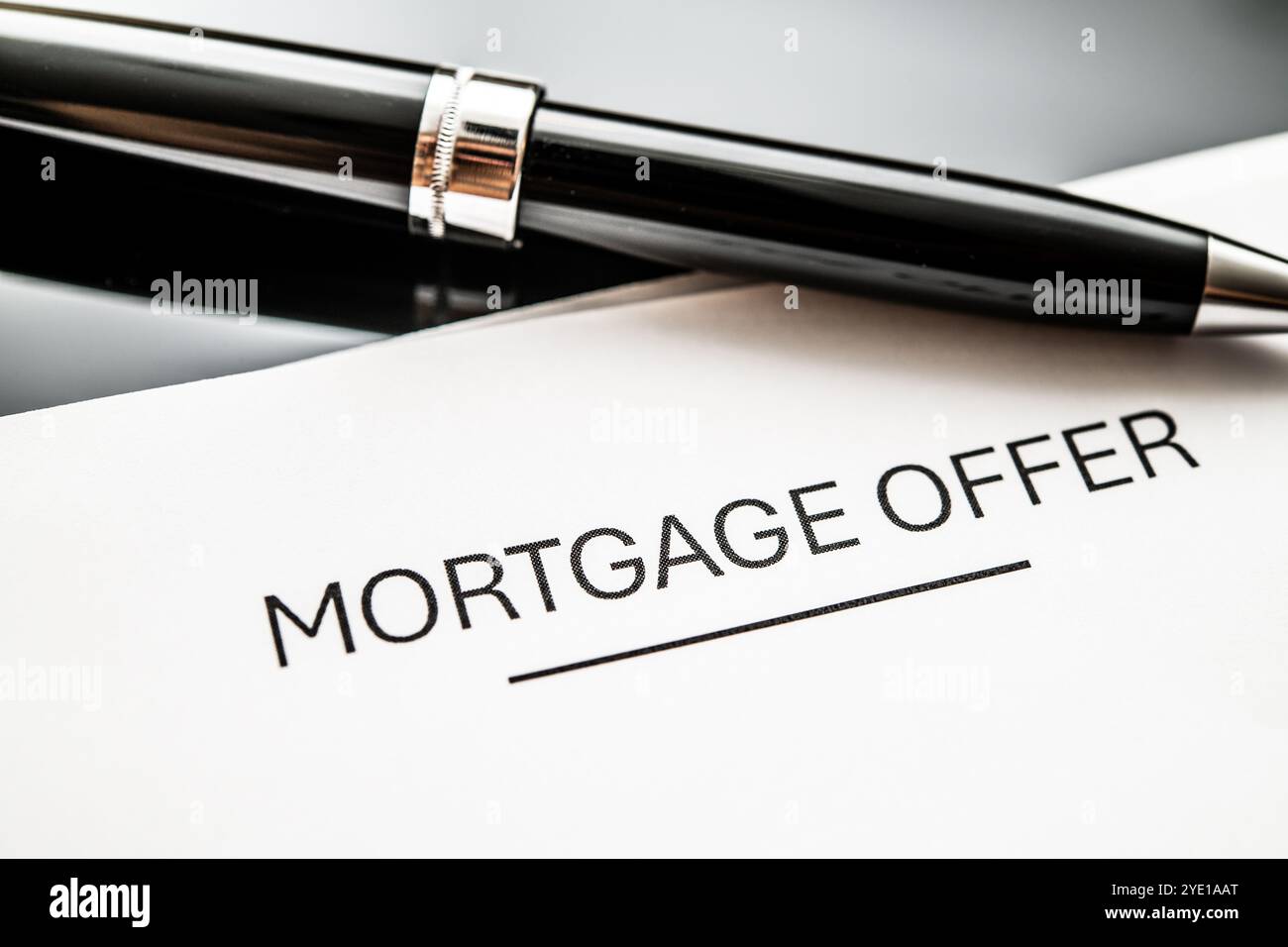 Documento di offerta ipotecaria con una penna elegante, che rappresenta il finanziamento domestico, le soluzioni immobiliari, i processi di richiesta ipotecaria e le decisioni cruciali per Foto Stock