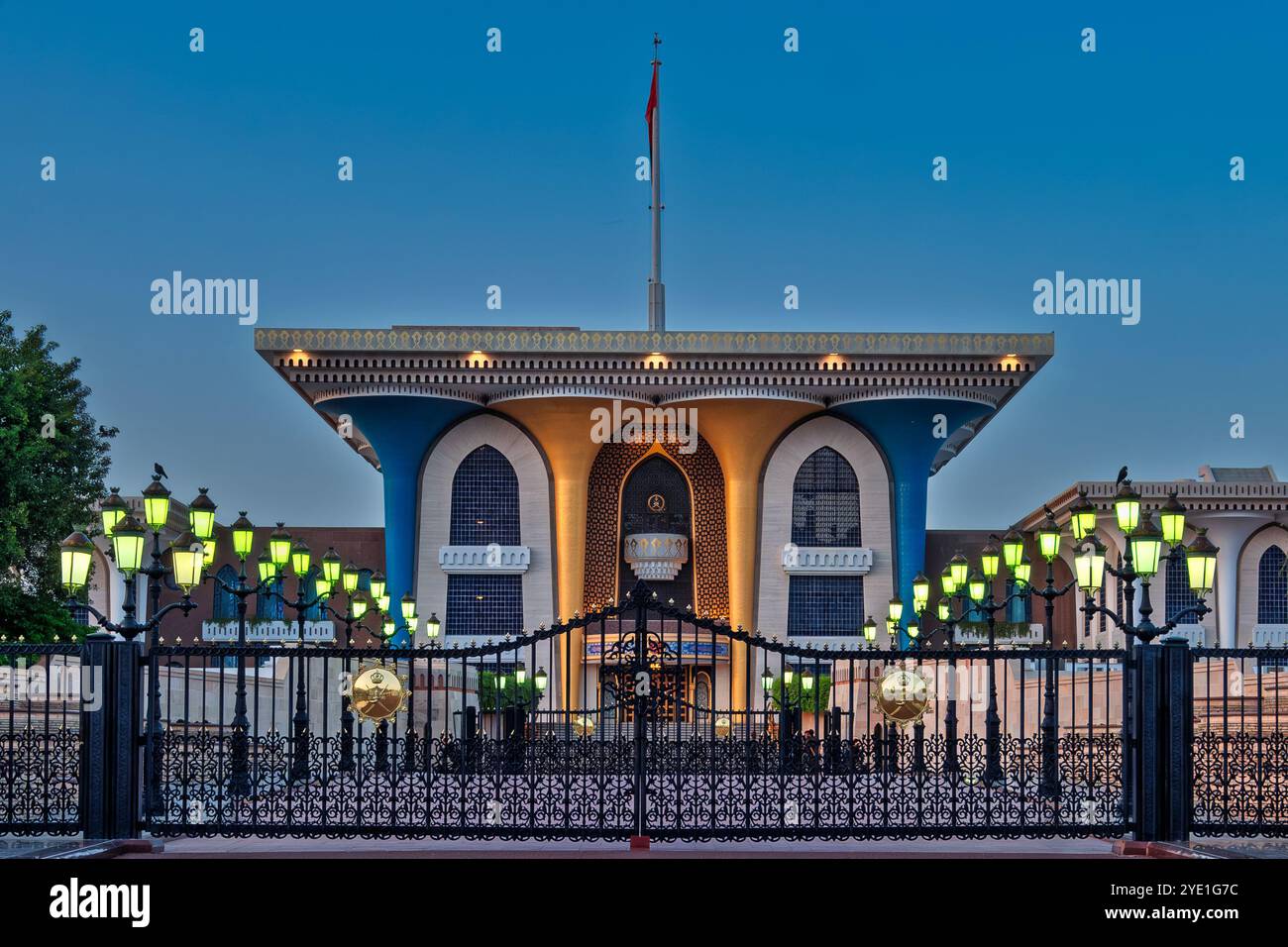 L'ingresso al Palazzo reale al Alam a Mascate, Oman, si illumina splendidamente sotto il sereno cielo blu dell'ora, evidenziandone la grandezza e il significato culturale Foto Stock