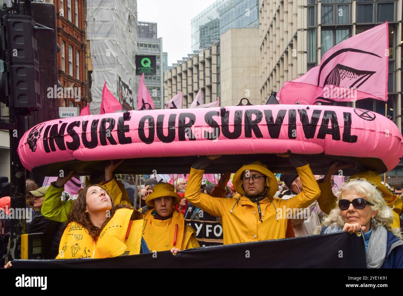Londra, Regno Unito. 28 ottobre 2024. Gli attivisti marciano con una barca gonfiabile segnata con "assicurati la nostra sopravvivenza" mentre la ribellione dell'estinzione inizia tre giorni di proteste nella City di Londra, il distretto finanziario della capitale, chiedendo alle compagnie assicurative di smettere di assicurare progetti di combustibili fossili. (Foto di Vuk Valcic/SOPA Images/Sipa USA) credito: SIPA USA/Alamy Live News Foto Stock