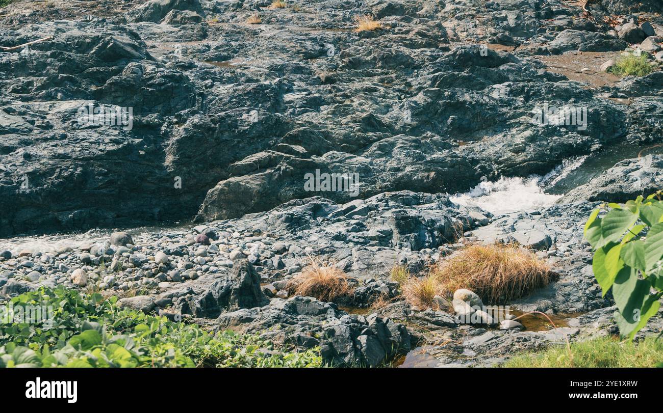 Grandi rocce fluviali che sembrano scorrere con l'acqua Foto Stock