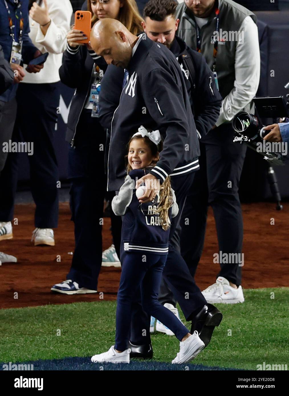 New York, Stati Uniti. 28 ottobre 2024. L'ex giocatore dei New York Yankees Derek Jeter viene accolto da una delle sue figlie dopo aver gettato fuori il primo campo cerimoniale prima dell'inizio della terza partita delle MLB World Series contro i Los Angeles Dodgers allo Yankee Stadium di New York City lunedì 28 ottobre 2024. Foto di John Angelillo/UPI credito: UPI/Alamy Live News Foto Stock