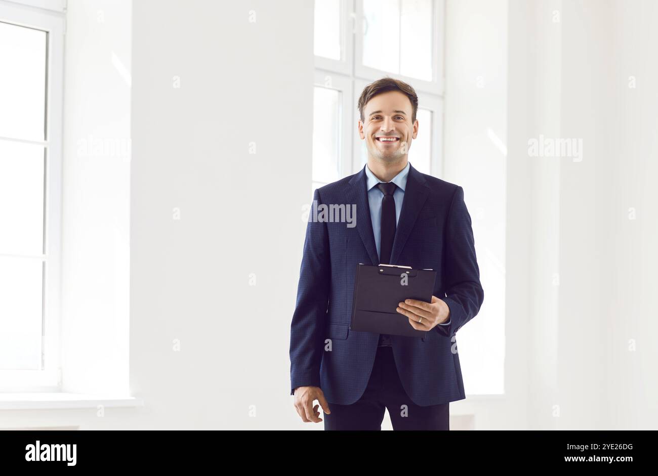 Ritratto di un agente immobiliare maschile professionale sorridente in una nuova casa o in un ufficio Foto Stock