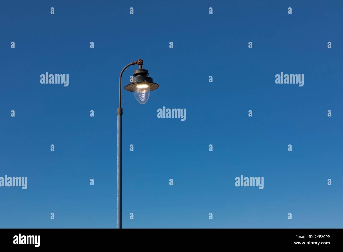Un semaforo illuminato contro un cielo azzurro Foto Stock