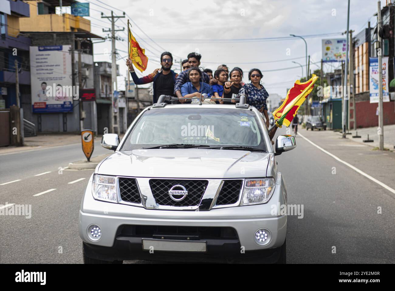 COLOMBO, SRI LANKA: 9 luglio 2022: Uomini e donne uniti sul retro del veicolo sventolando bandiera nazionale durante la protesta di massa per la cattiva gestione del governo Foto Stock
