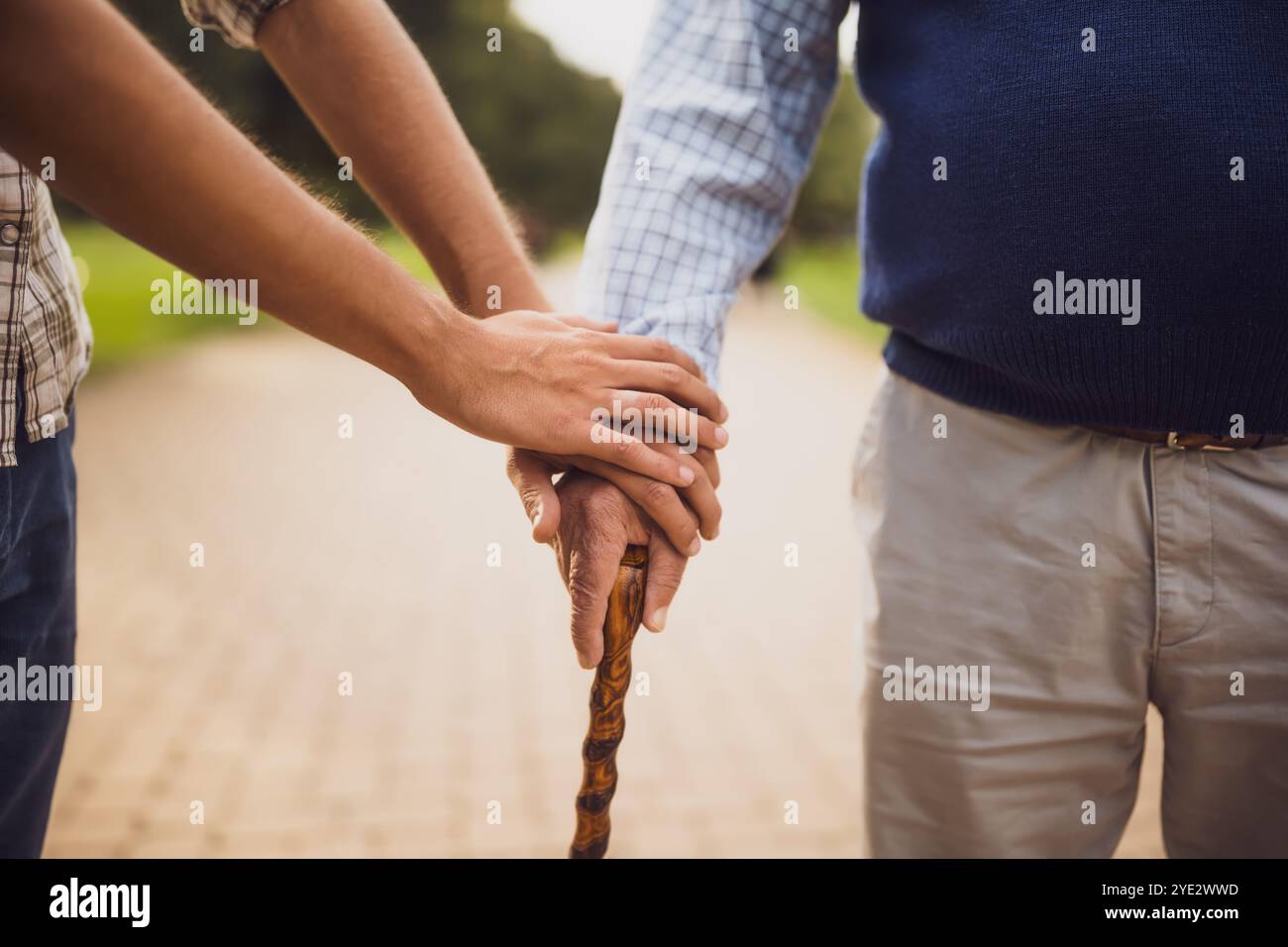 Primo piano della mano di un giovane che tiene la mano di un anziano. Foto Stock