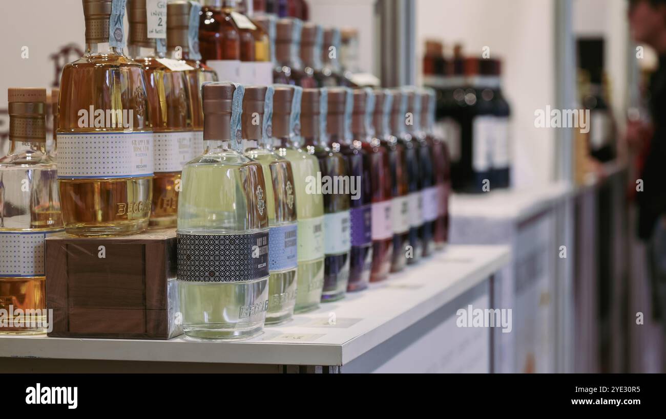I visitatori esplorano il Festival del Tartufo d'Alba in Italia, ammirando una serie di liquori locali e prodotti gourmet fiancheggiati in mostra. L'evento evidenzia cu Foto Stock