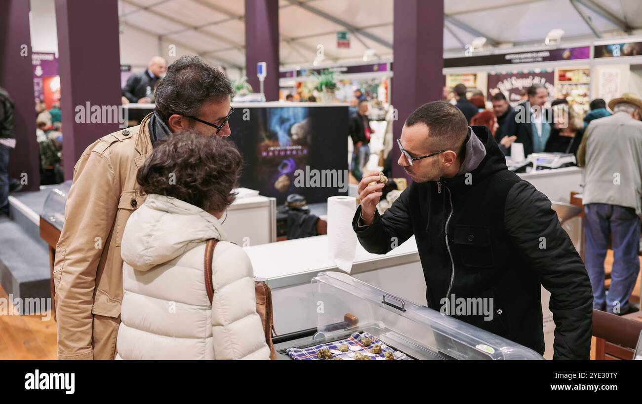 La folla si riunisce al Festival del Tartufo d'Alba in Italia, dove i partecipanti assaggiano vari piatti e prodotti al tartufo Foto Stock