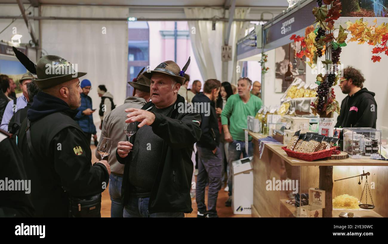 I visitatori si confrontano con i venditori locali al Festival del Tartufo d'Alba in Italia, esplorando le prelibatezze del tartufo e le delizie culinarie Foto Stock