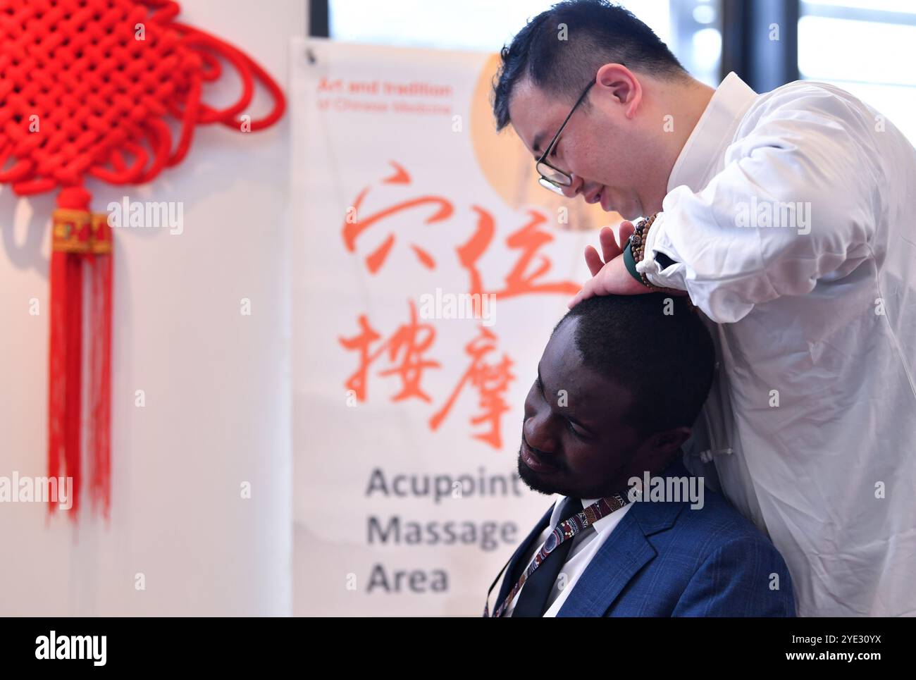 Ginevra, Svizzera. 28 ottobre 2024. Un partecipante si gode un massaggio acupoint durante un evento di medicina tradizionale cinese al Palais des Nations di Ginevra, Svizzera, 28 ottobre 2024. PER ANDARE CON "Feature: Palais des Nations traboccante di saggezza della medicina tradizionale cinese" credito: Lian Yi/Xinhua/Alamy Live News Foto Stock