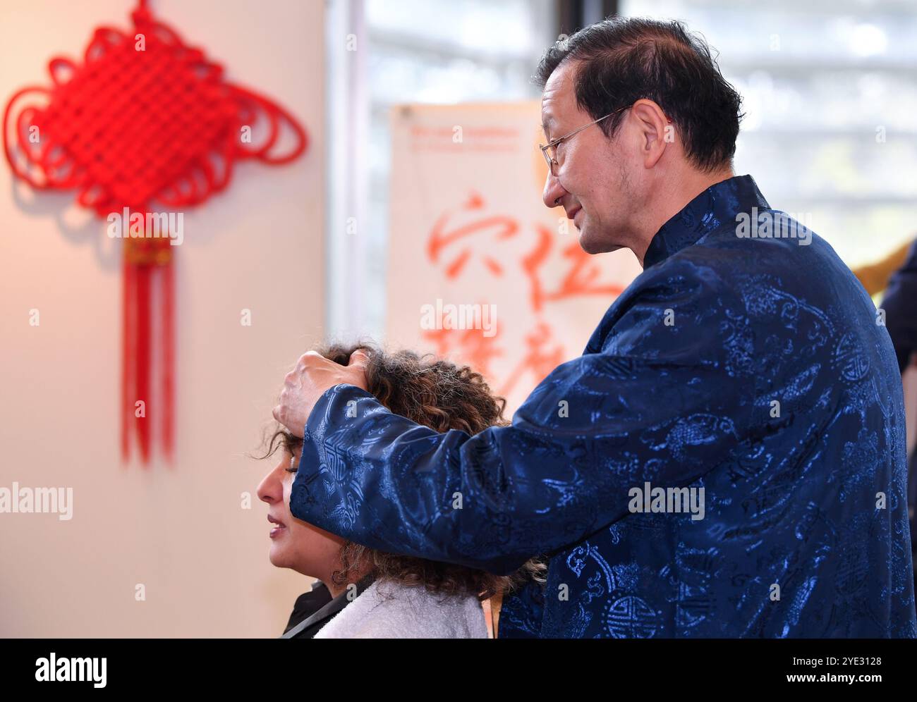Ginevra, Svizzera. 28 ottobre 2024. Un partecipante si gode un massaggio acupoint durante un evento di medicina tradizionale cinese al Palais des Nations di Ginevra, Svizzera, 28 ottobre 2024. PER ANDARE CON "Feature: Palais des Nations traboccante di saggezza della medicina tradizionale cinese" credito: Lian Yi/Xinhua/Alamy Live News Foto Stock