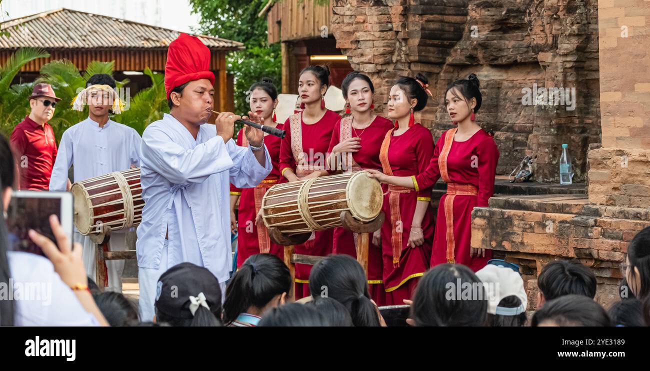 L'uomo asiatico suona il flauto. Artisti vietnamiti che eseguono musica e balli tradizionali. Musicisti che suonano un flauto e una batteria in abiti tradizionali Foto Stock