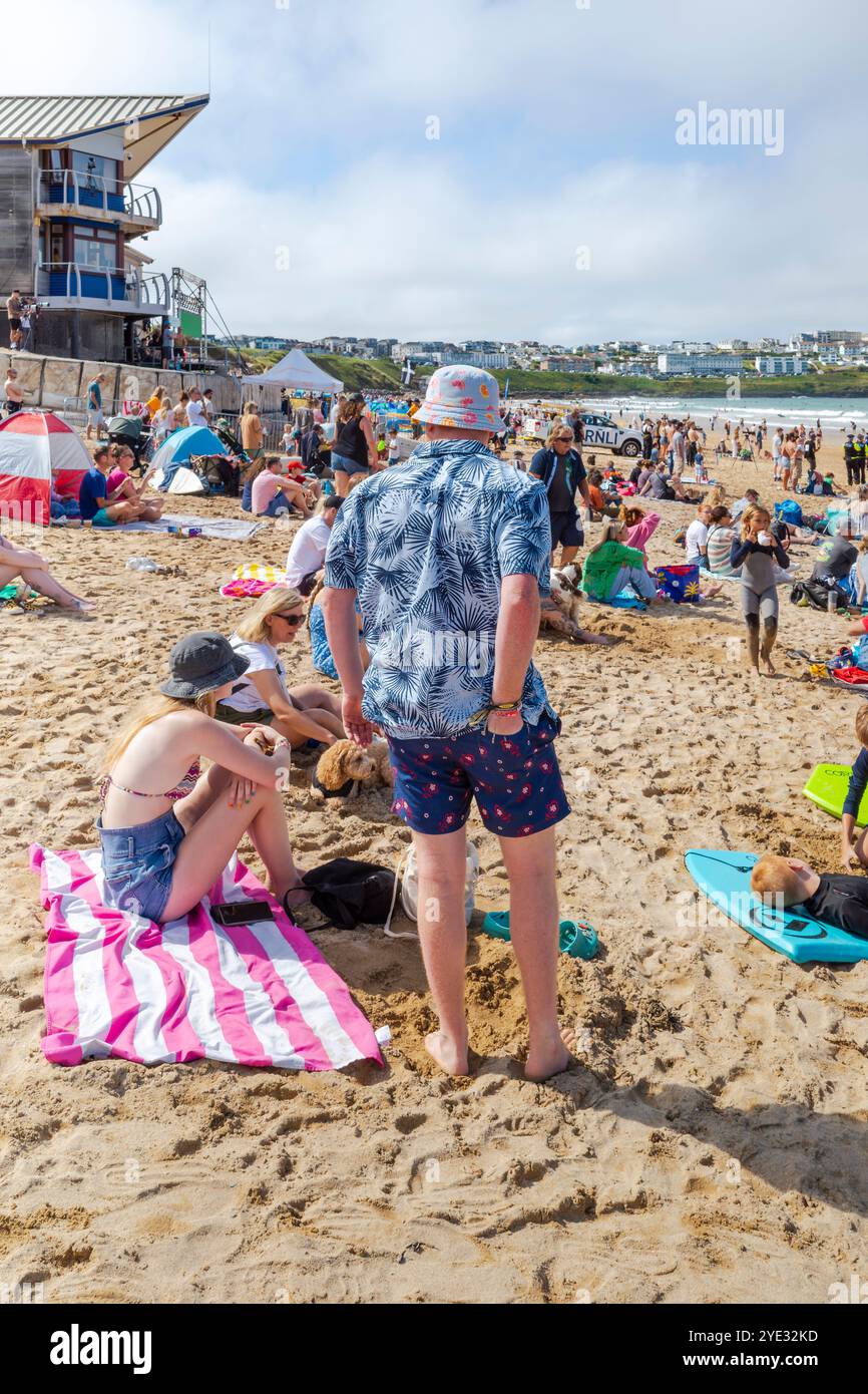 Turisti che si godono il sole estivo sull'iconica spiaggia Fistral di Newquay, in Cornovaglia, nel Regno Unito. Foto Stock