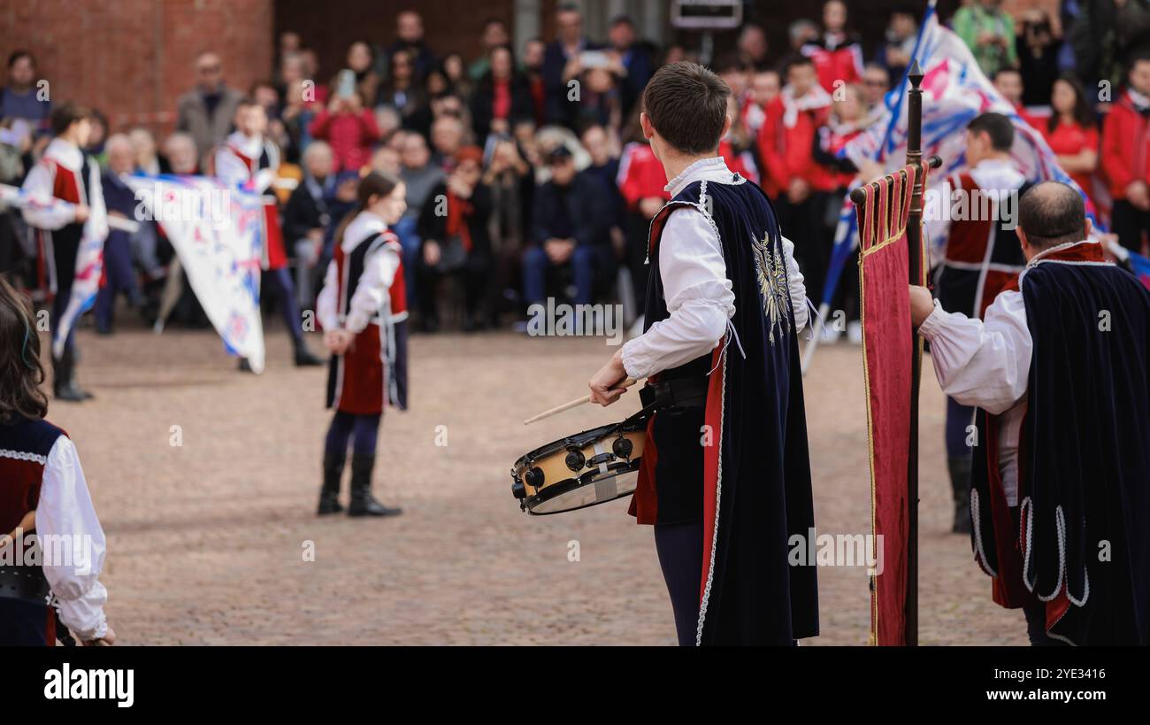 La folla si riunisce ad Alba, in Italia, mentre musicisti e artisti mettono in mostra danze e musica tradizionali durante un vivace festival locale, creando un'atmosfera Foto Stock