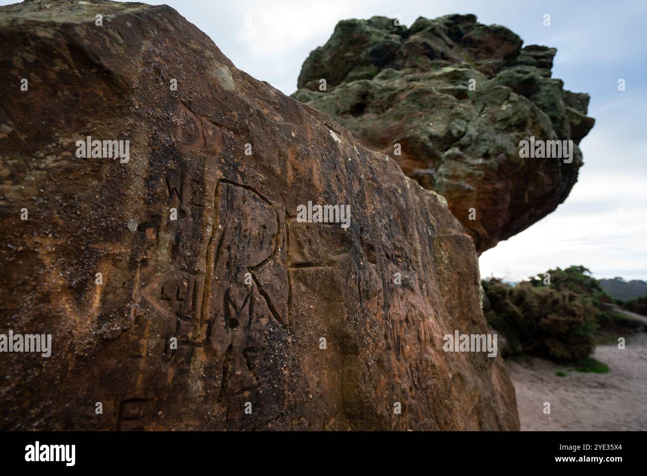 Agglestone Rock a Godlingston Heath, Studland, Dorset - un'importante pietra arenaria ricoperta di graffiti scolpiti Foto Stock