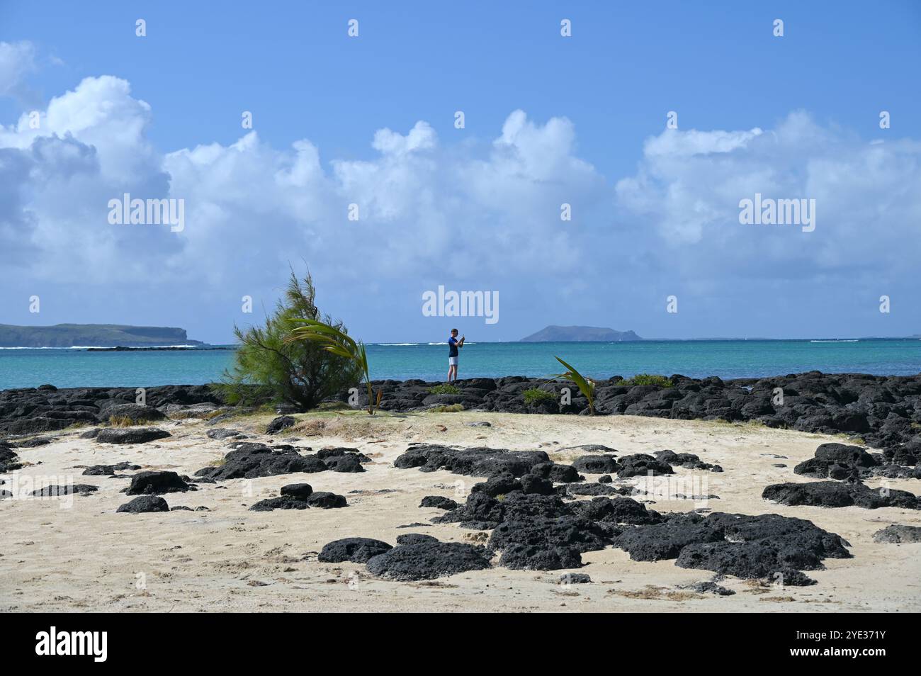 Il turista sta sta facendo delle foto sulla spiaggia di Mauritius in una giornata di sole. Foto Stock