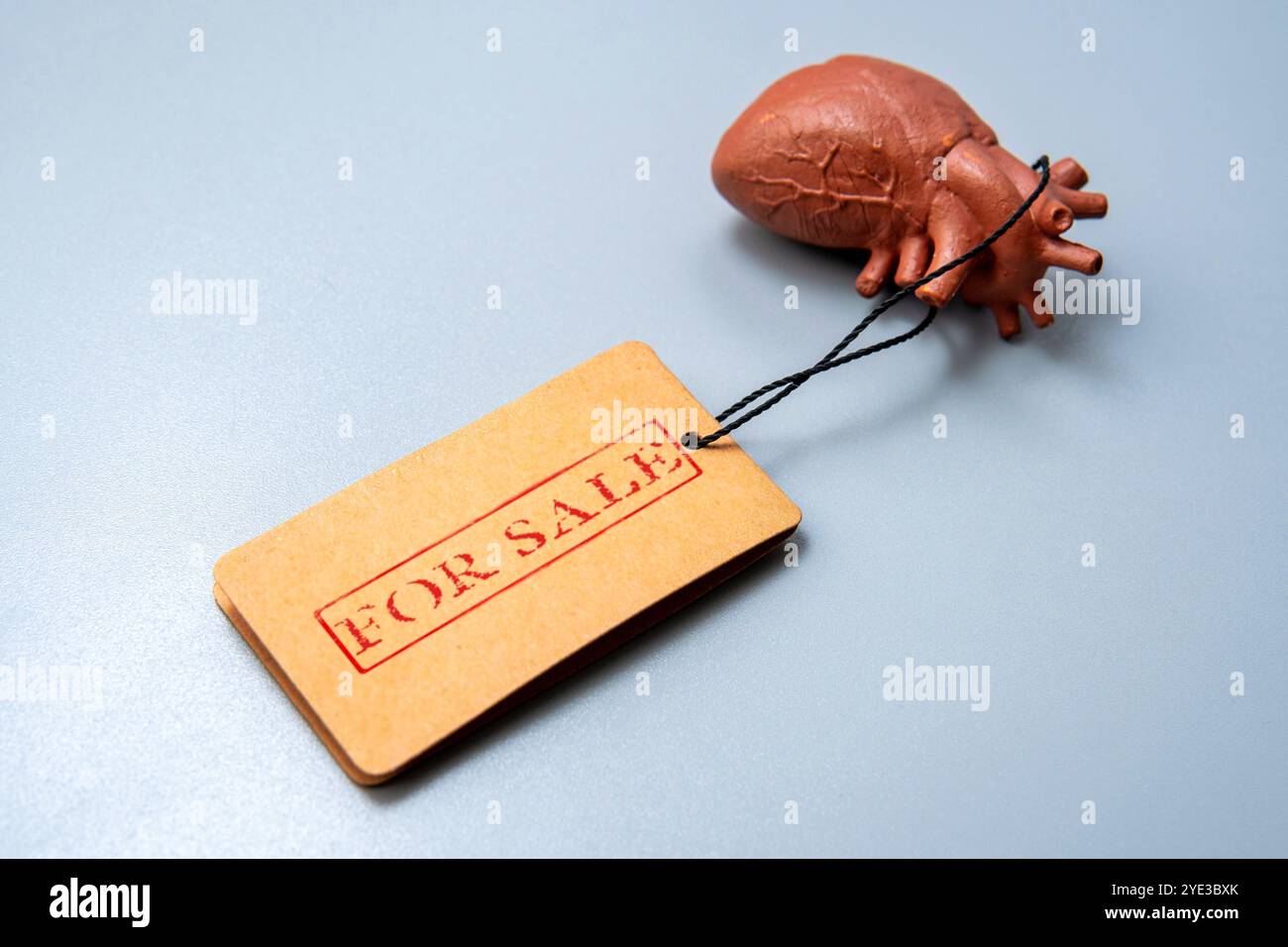 Un modello di cuore umano con un'etichetta in vendita. Concetto di traffico di organi e di modifica delle parti del corpo umano. Foto Stock