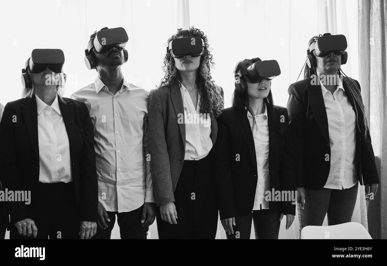 Persone aziendali che indossano occhiali vr all'interno dell'ufficio - nuova tecnologia e concetto metaverso - attenzione principale ai volti centrali - editing in bianco e nero Foto Stock