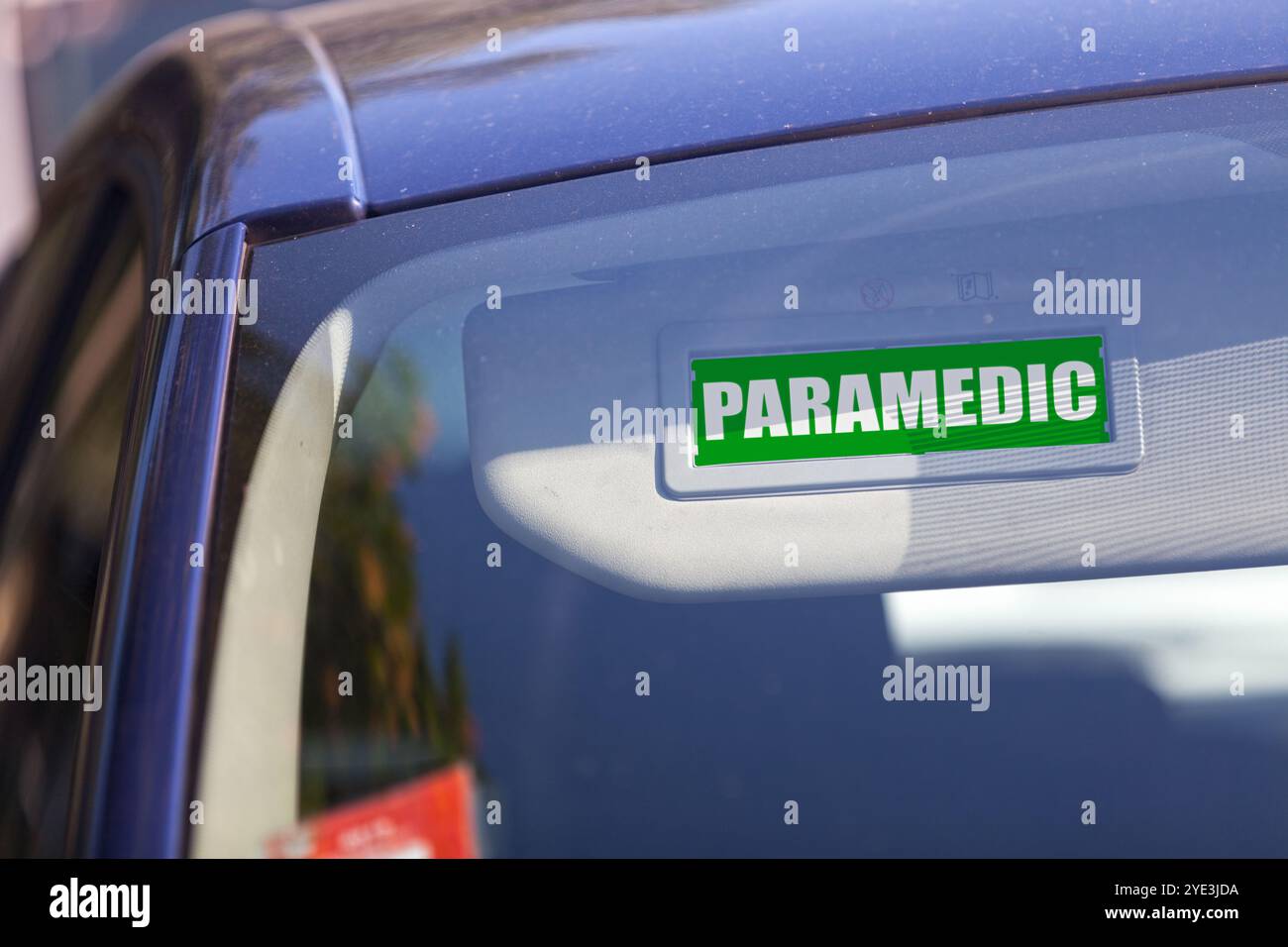Visiera parasole con un cartello paramedico verde. Foto Stock