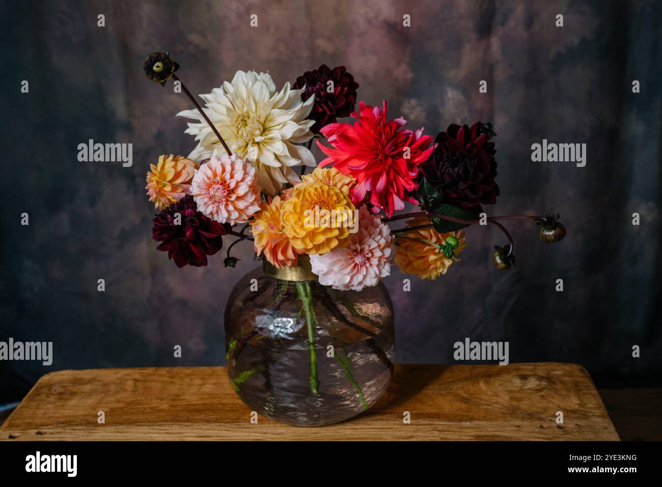 Grande bouquet di fiori autunnali dahlias e asters in tonalità arancio, Bordeaux, bianco e giallo in un vaso in piedi su una panchina di legno Foto Stock