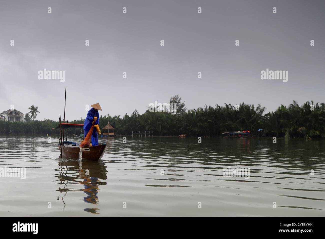 Pescatore in un canale della foresta di noci di cocco di sette acri a Hoi An, Vietnam Foto Stock