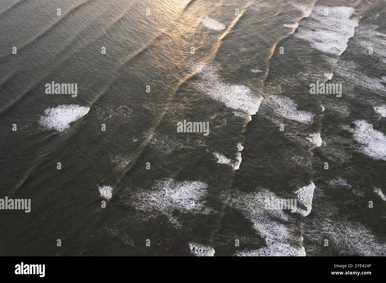 Sfondo delle onde verdi dell'oceano con luce solare arancione vista aerea dei droni Foto Stock