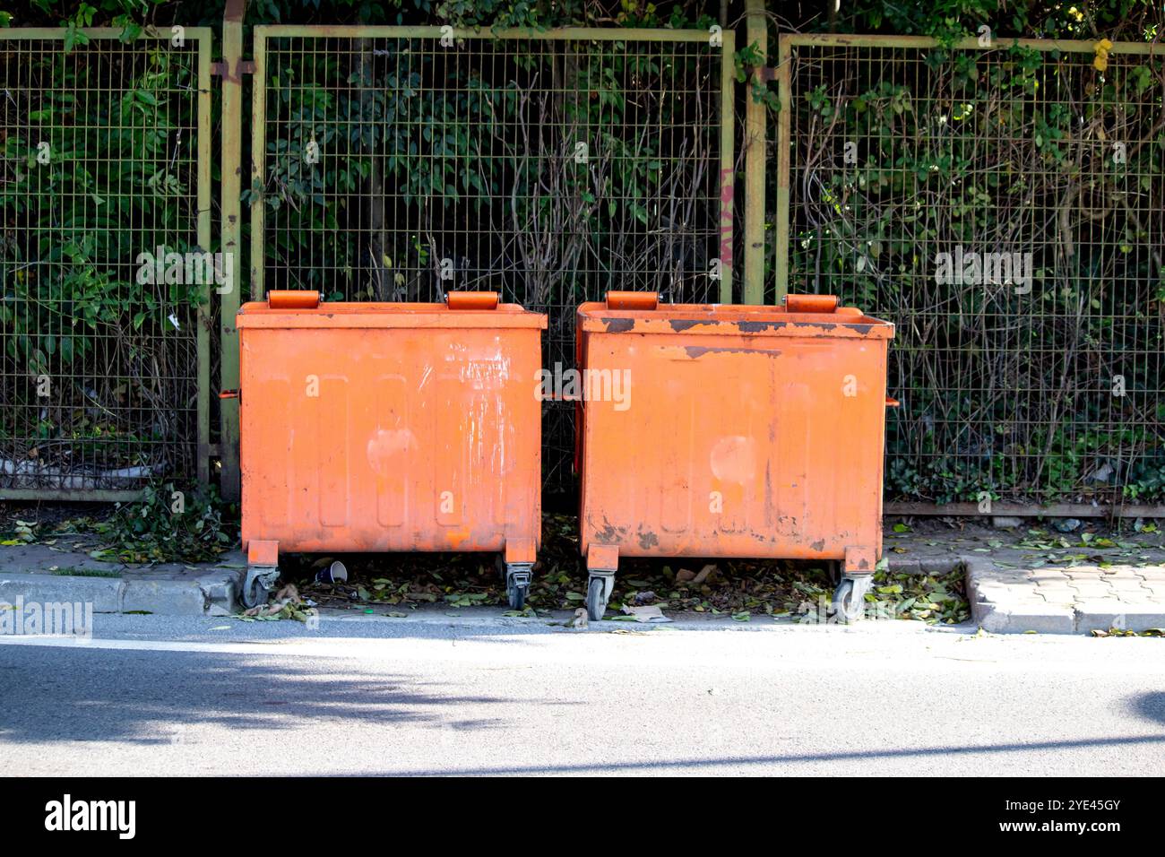 Due contenitori arancioni per la spazzatura. Concetto di riciclo. Grandi contenitori per rifiuti con coperchi incernierati. Foto orizzontale. Niente persone, nessuno. All'aperto. Foto Stock