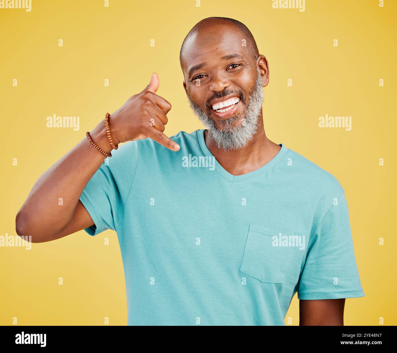 Uomo maturo, ritratto e nero con gesti telefonici per chiamarmi, appendi il cartello o Shaka su uno sfondo giallo dello studio. Africano, uomo o felice Foto Stock