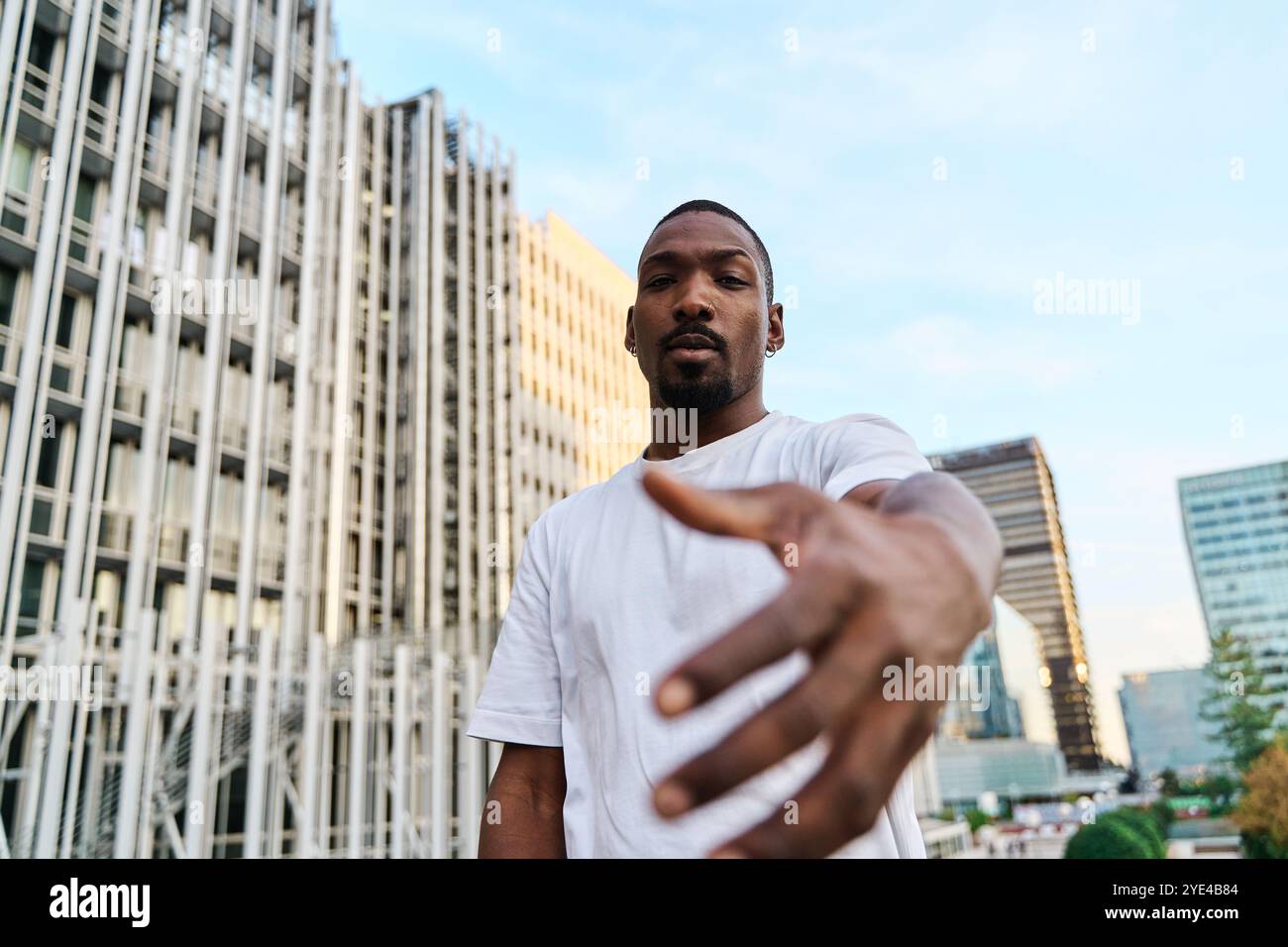 Attraente giovane uomo d'affari afroamericano che stringe la mano per chiudere un affare o salutare Foto Stock