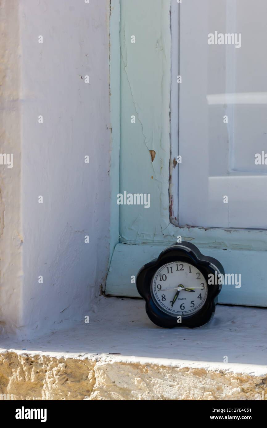 Orologio a forma di fiore nero su davanzale in pietra Foto Stock
