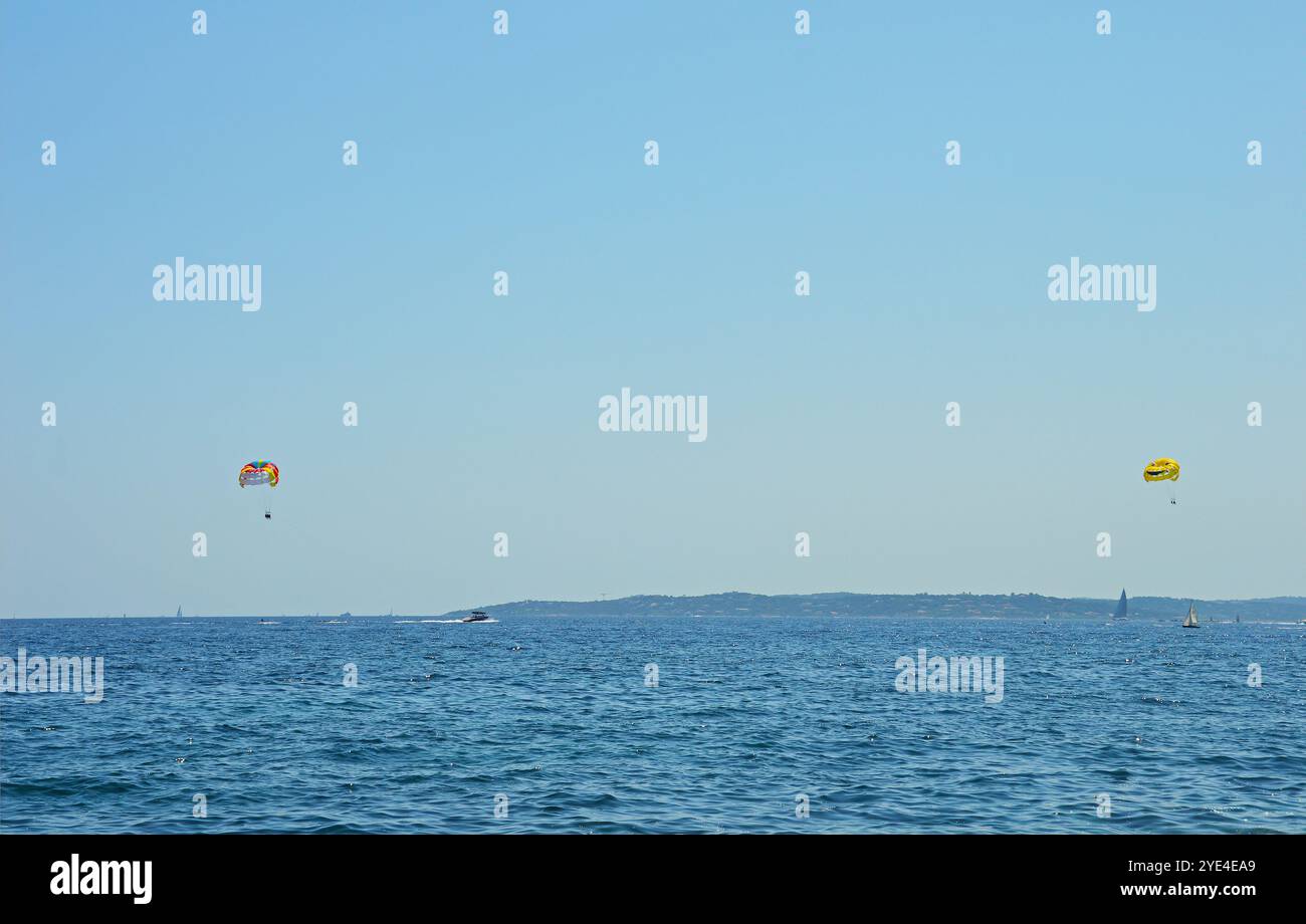 Paracadute sul mare через cielo azzurro І acqua limpida del mare, trainando su una barca. Il concetto di viaggio, estate, riposo Foto Stock