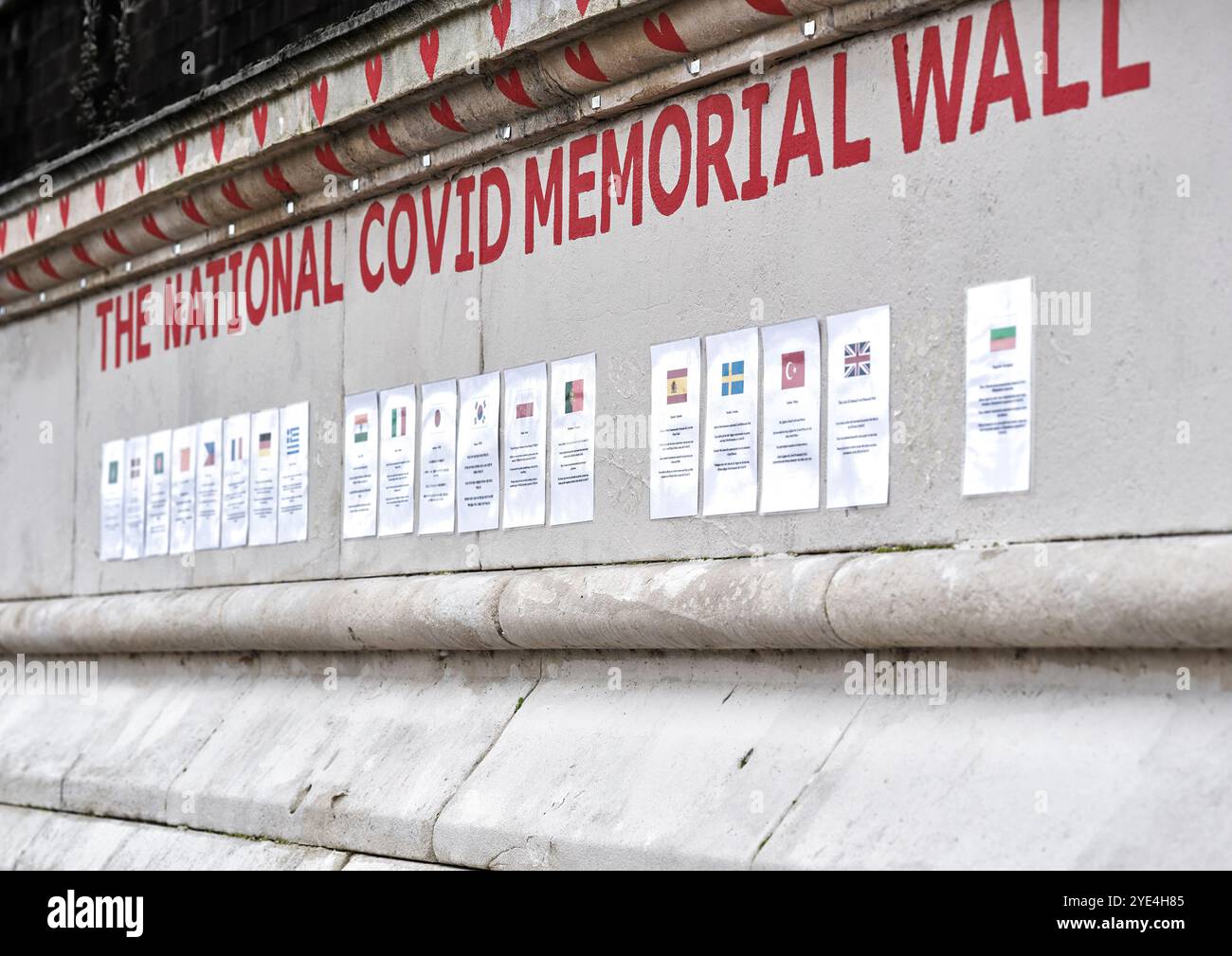 Cuori dipinti di rosso sul muro del National Covid Memorial sulla riva sud del Tamigi, di fronte alla Houses of Parliament, Londra, Inghilterra. Foto Stock