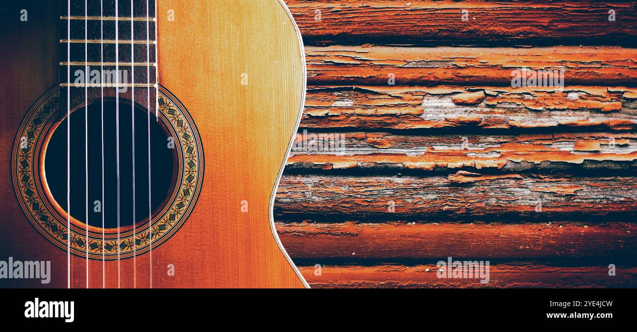 Chitarra spagnola e muro di legno. Musica di sottofondo. Design musicale con chitarra acustica Foto Stock