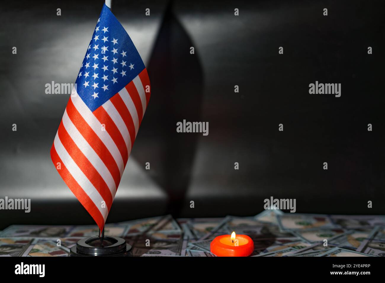 Bandiera americana tra banconote da un dollaro su sfondo nero Foto Stock