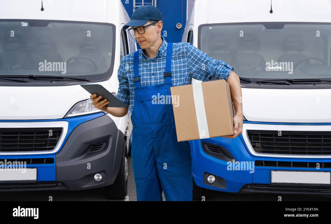 Addetto alle consegne in uniforme con tablet digitale. Foto Stock