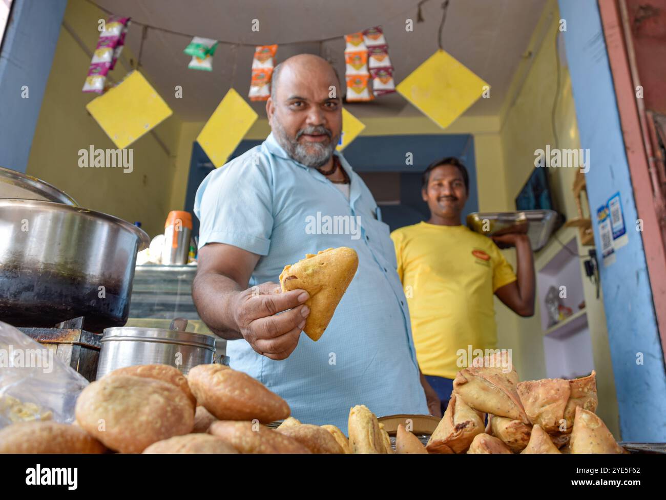 Venditore che offre tradizionale spuntino Namkeen e Samosas su cibo di strada e mercati a Jaipur, India. Foto Stock