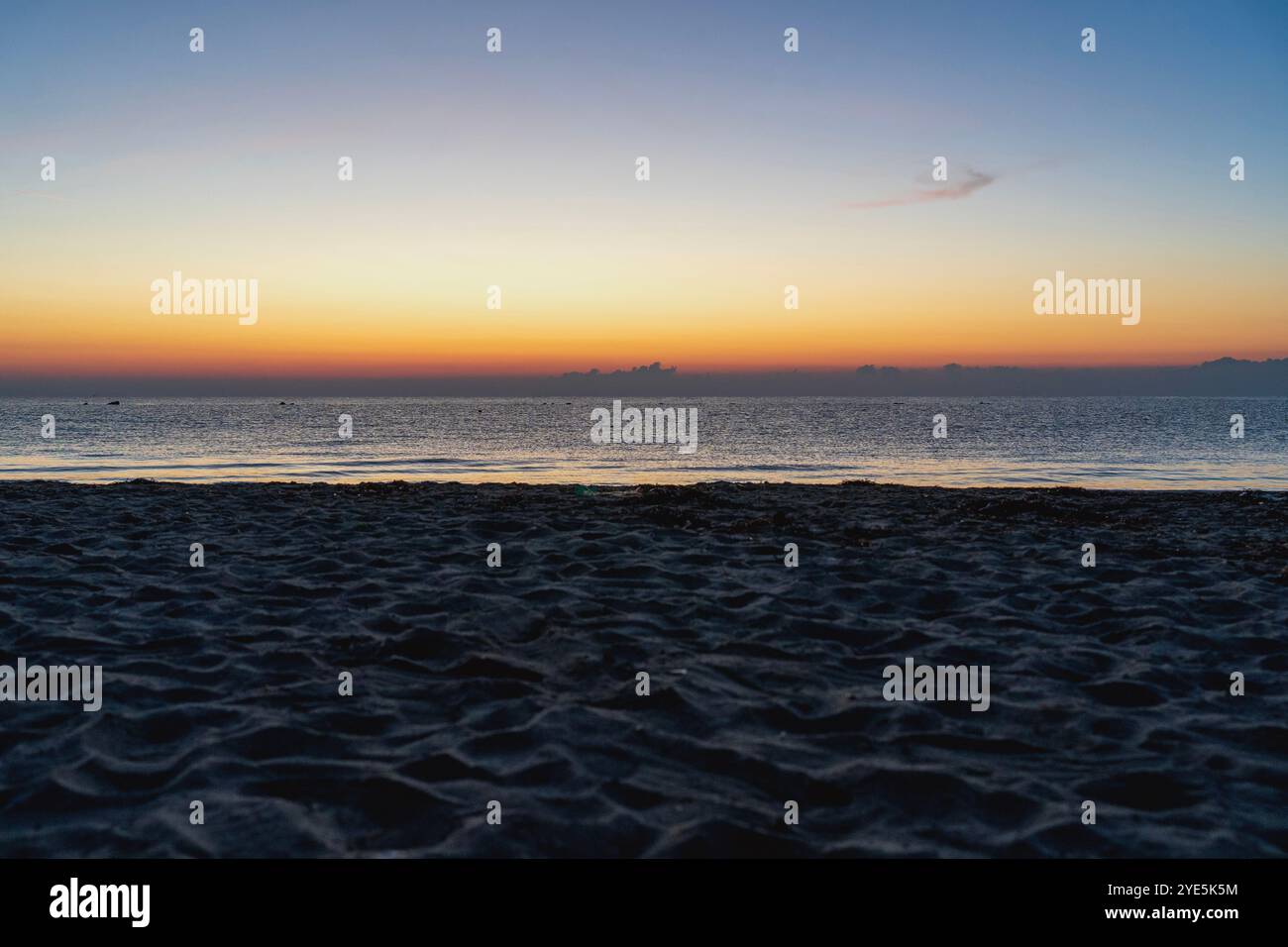 Alba sull'Egeo sulla spiaggia di sabbia: Bellezza fuori stagione nelle tonalità arancione e blu Foto Stock