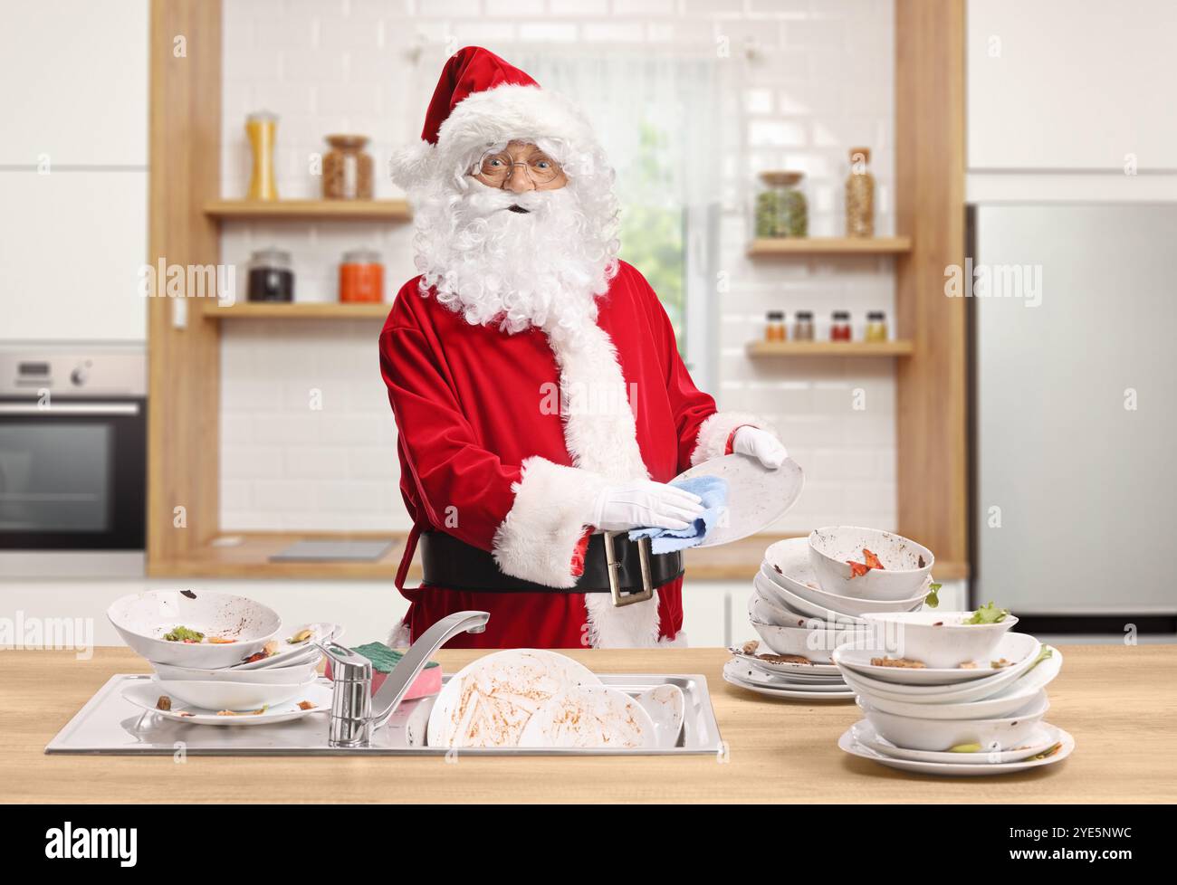 Babbo natale con un mucchio di piatti sporchi in cucina Foto Stock