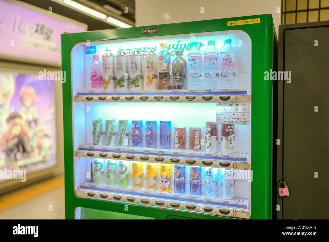 Distributore automatico con una varietà di bevande, tra cui acqua, bibite gassate e succo di frutta. La macchina è verde e ha un blocco Foto Stock