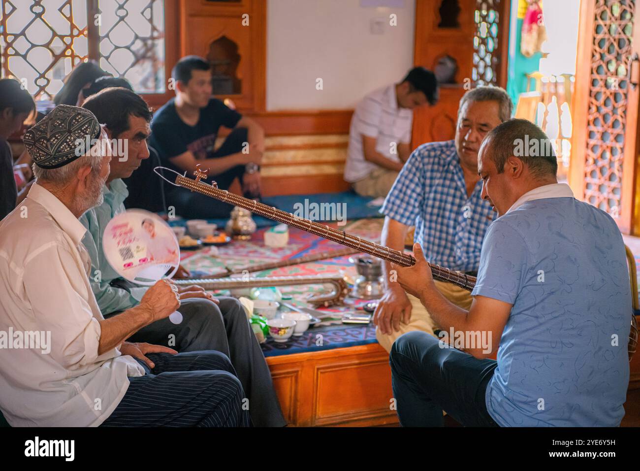 Kashgar, Xinjiang, Cina - 17 LUGLIO 2023: Uomini uiguri che suonano strumenti musicali tradizionali nella Old Tea House nella città antica di Kashgar Foto Stock