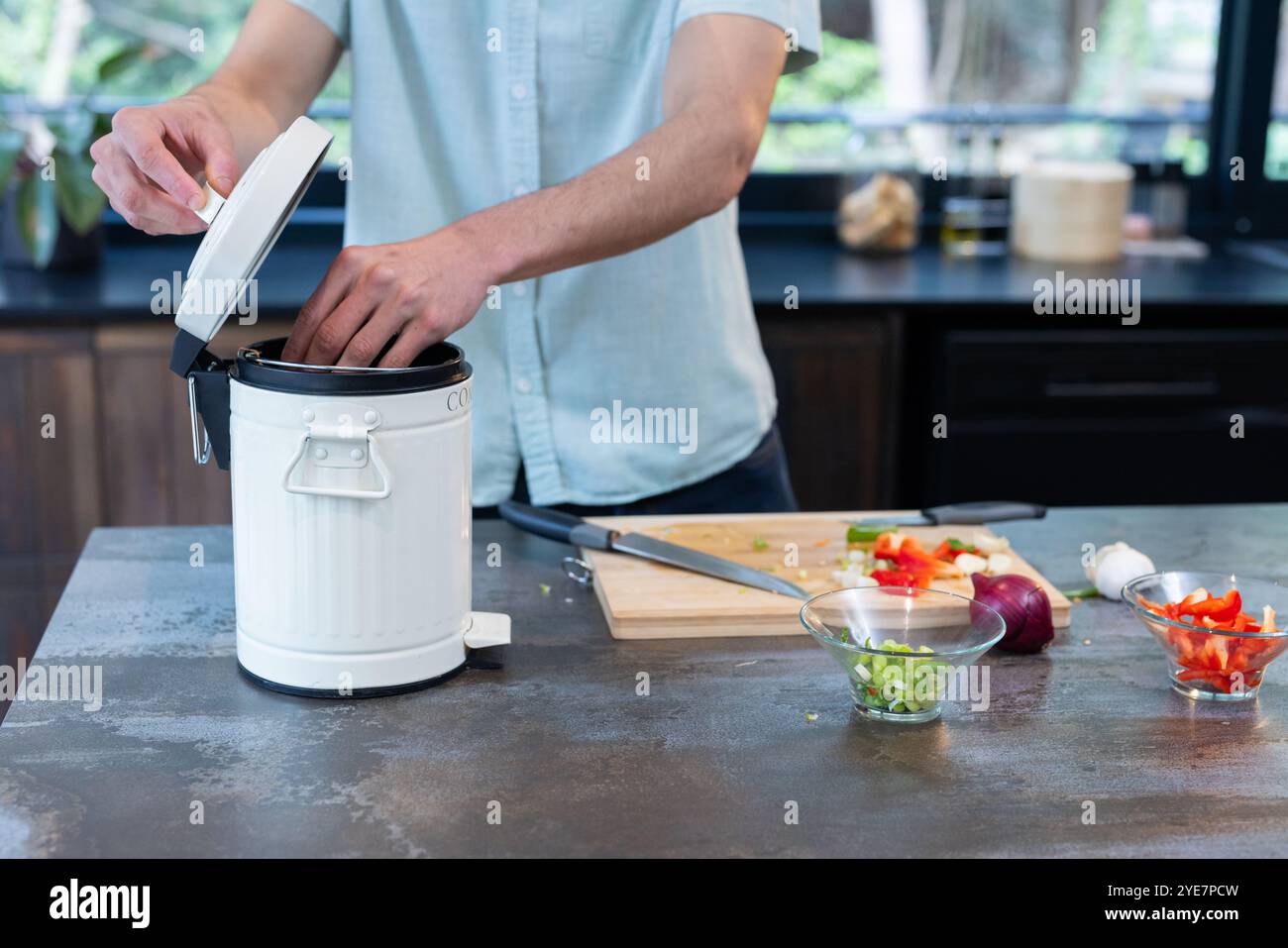 Compostaggio di scarti vegetali, uomo in cucina che promuove uno stile di vita ecologico, a casa Foto Stock