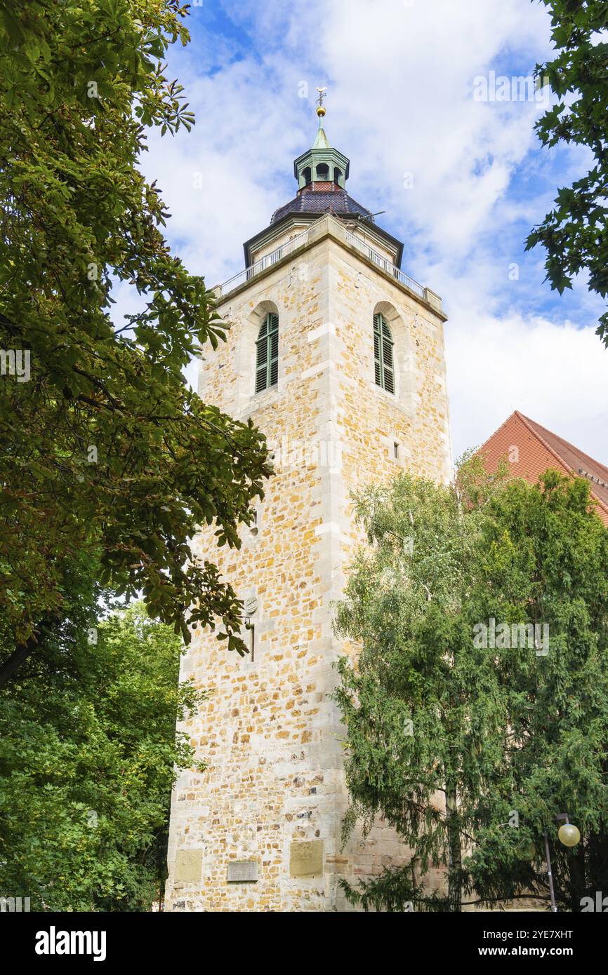 Una torre di chiesa in pietra con alberi in primo piano e cielo blu sullo sfondo, Kirchheim Teck, Germania, Europa Foto Stock