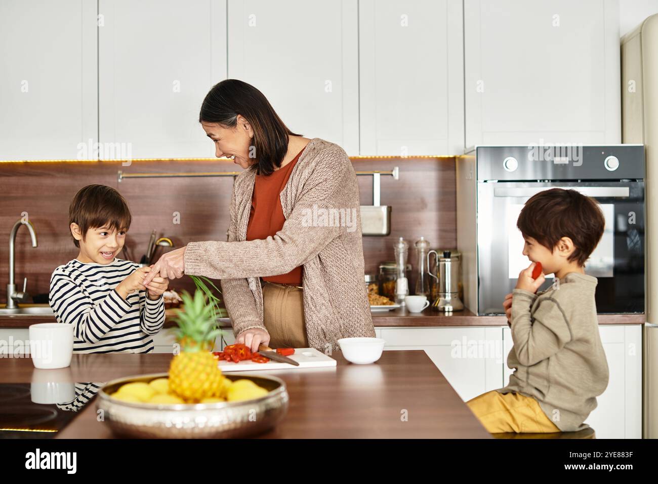 Una famiglia asiatica felice ama cucinare insieme, con bambini che aiutano in cucina prima di Natale. Foto Stock