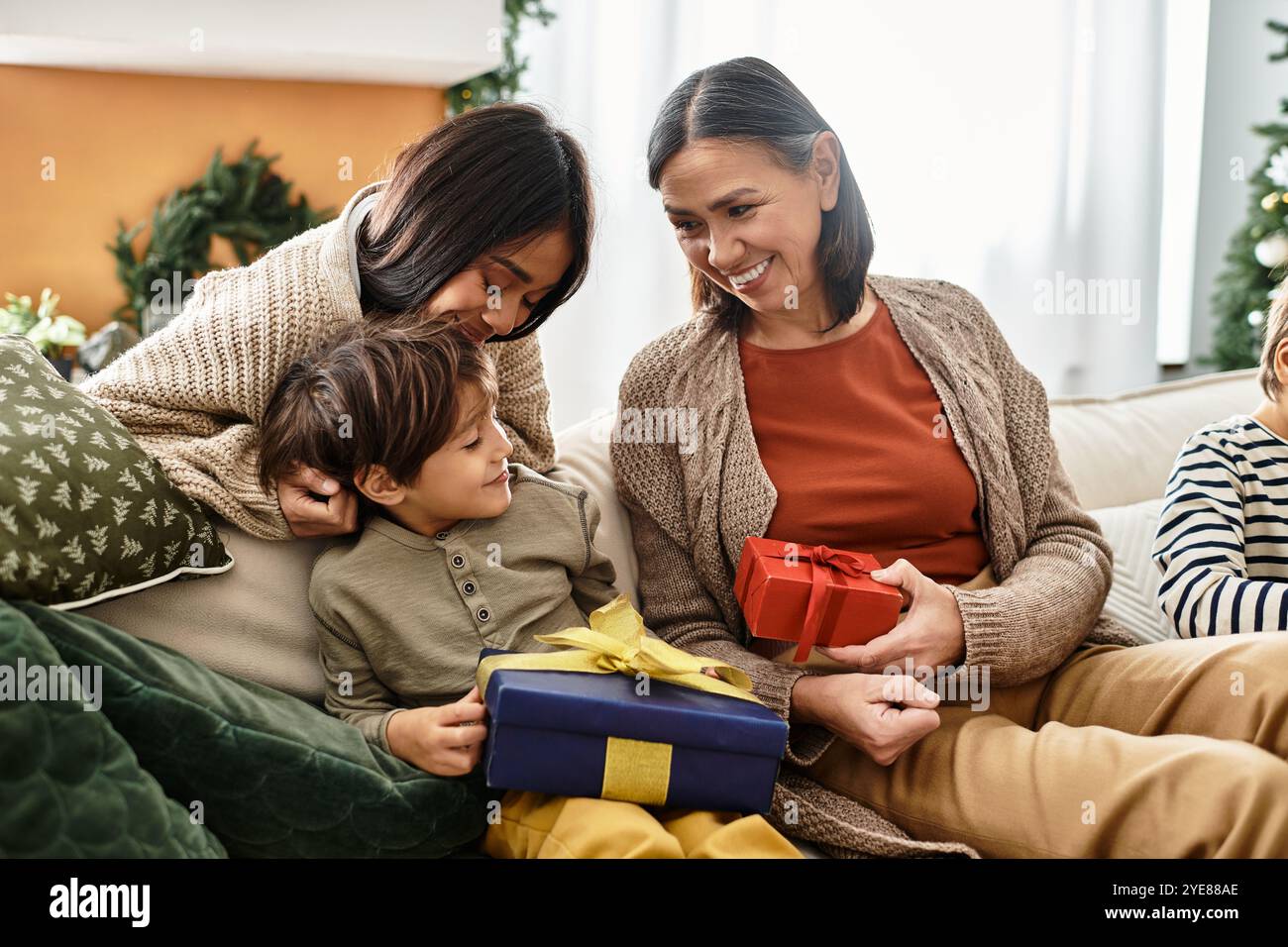 Una famiglia felice gode del calore del Natale, scambiandosi regali e creando ricordi preziosi insieme. Foto Stock