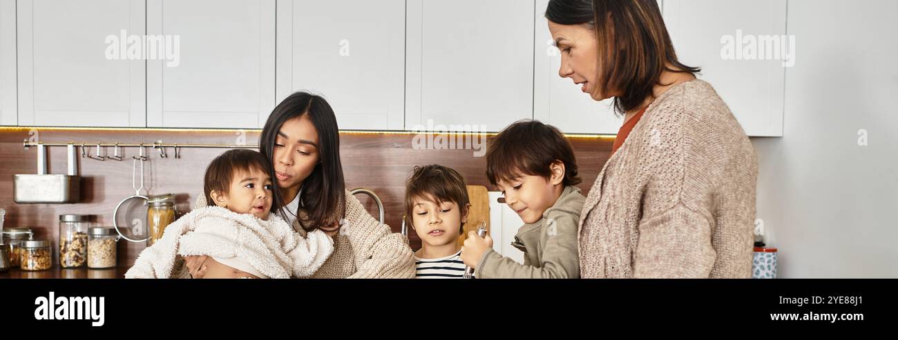 Una famiglia gioiosa si riunisce in una cucina moderna, preparando insieme le prelibatezze natalizie prima di Natale. Foto Stock