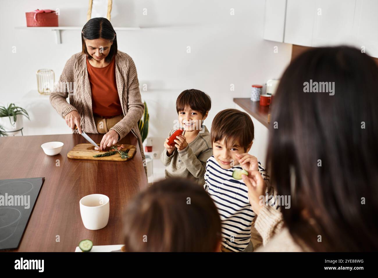 Una famiglia asiatica ama cucinare insieme nella sua elegante cucina mentre i bambini aiutano con le preparazioni natalizie. Foto Stock